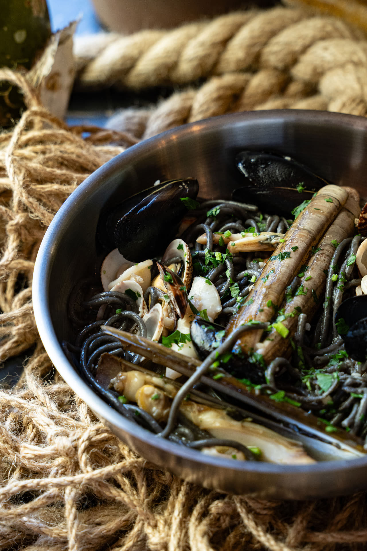 Crni špageti s prstacima – Poreč Crni špageti s prstacima i dagnjama servirani u tavi – specijalitet od školjki iz vlastitog uzgoja, Oli Mare Poreč | squid ink pasta with razor clams Croatia