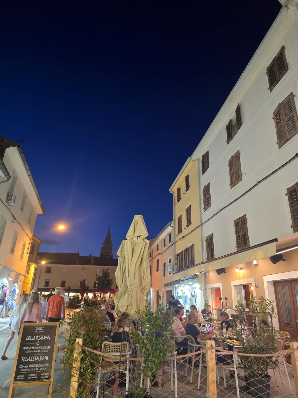 Terasa Oli Mare navečer – Poreč Terasa ribljeg restorana Oli Mare Fish & Wine navečer u starom gradu Poreču – gosti i ploča s ponudom | fish restaurant terrace by night Porec