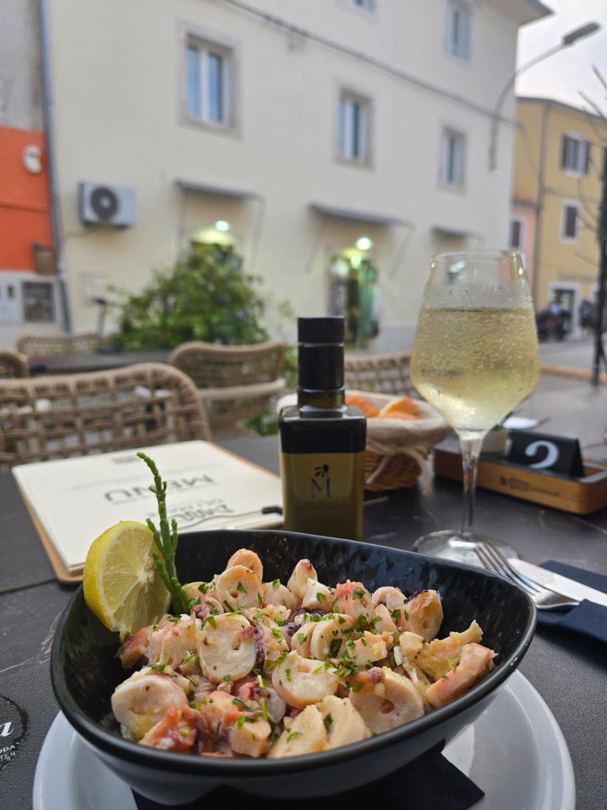 Salata od hobotnice uz vino – Poreč Salata od hobotnice i lignji uz čašu istarskog bijelog vina na terasi – Oli Mare Fish & Wine Poreč | octopus salad and wine